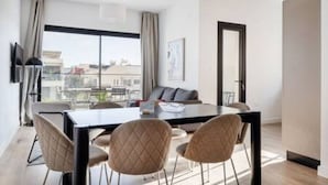 A modern hotel room with a dining area, large windows, and a view of the city. - 101 Piliou City View & Shared Rooftop Pool (Limassol)