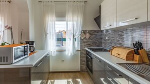 Eine moderne Küche mit Mikrowelle, Kaffeemaschine und Schneidebrett.