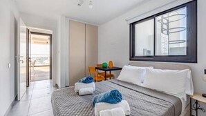 Une chambre d’hôtel avec un lit, un bureau, une chaise et une fenêtre.