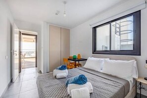 Ein Hotelzimmer mit Bett, Schreibtisch, Stuhl und Fenster.