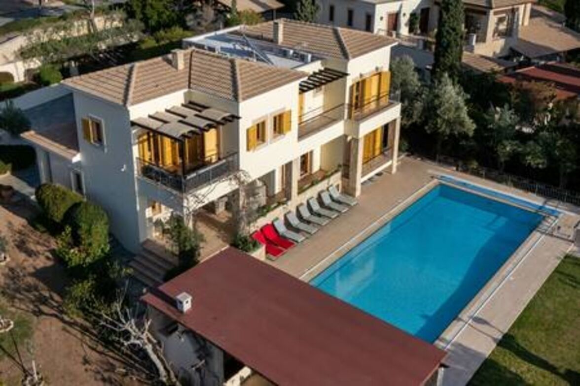A multi-story residential building with a swimming pool, balconies, and a garden area.