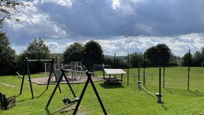 A playground with swings, a climbing structure, and a picnic table.