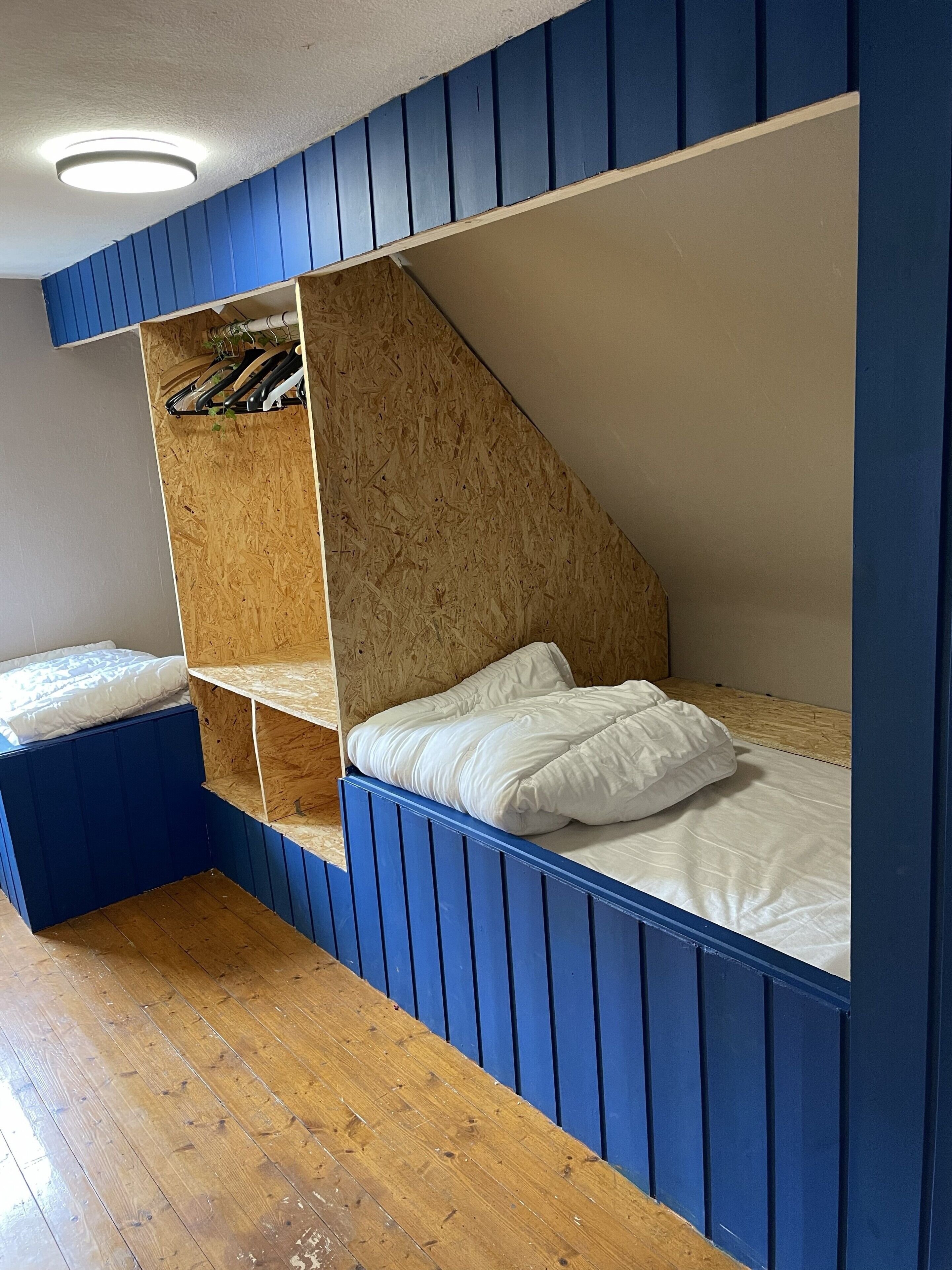 Ein Zimmer mit Etagenbett, Holzböden und schrägem Dach.