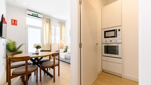 A compact living space with a dining area, kitchenette, and a door leading to another room. - (SDB1L2) 1 bedroom apartment in Tetuán, Madrid (Madrid)