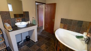 A bathroom with a sink, mirror, toilet, and bathtub.