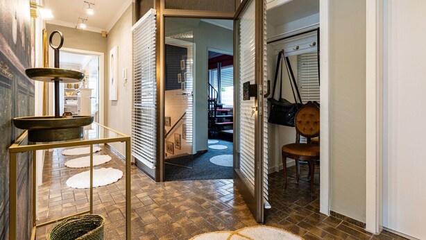 Un intérieur moderne avec un escalier, un coin repas comprenant une chaise et une table décorative.