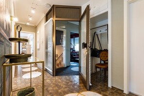 Un interior moderno con una escalera, un área de comedor con una silla y una mesa decorativa.