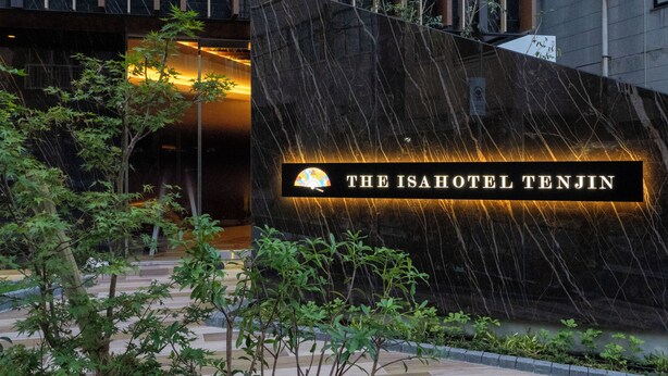 L'ingresso di un hotel con un cartello che recita 'The Isahotel Tenjin' e una moderna facciata.