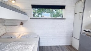 A compact room with a bunk bed, a small window, and a kitchenette. - Skummeslöv Family Hosue (Skummesloevsstrand)