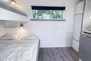 A compact room with a bunk bed, a small window, and a kitchenette. - Skummeslöv Family Hosue (Skummesloevsstrand)