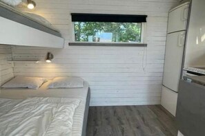 A compact room with a bunk bed, a small window, and a kitchenette. - Skummesloev Family Escape L (Skummesloevsstrand)