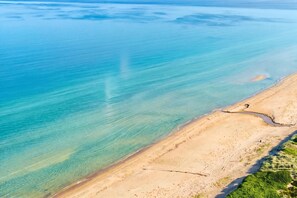 An aerial view of a beach with clear blue water and a sandy shoreline. - Skummeslöv Family Hosue (Skummesloevsstrand)