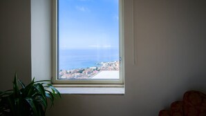Ein Fenster mit Blick auf eine Küstenstadt.