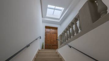 Eine Treppe mit Oberlicht, Holztüren und einer Brüstung.