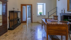 A room with a wooden desk, a chair, a cabinet, a window with a view, and a staircase.