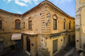 Una calle estrecha con edificios históricos, un acceso cubierto y un farol.