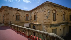 A historic building with arched windows and a red-tiled roof.