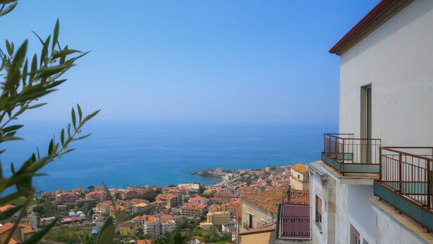 Une ville côtière avec des bâtiments, un ciel bleu dégagé et la mer en arrière-plan.