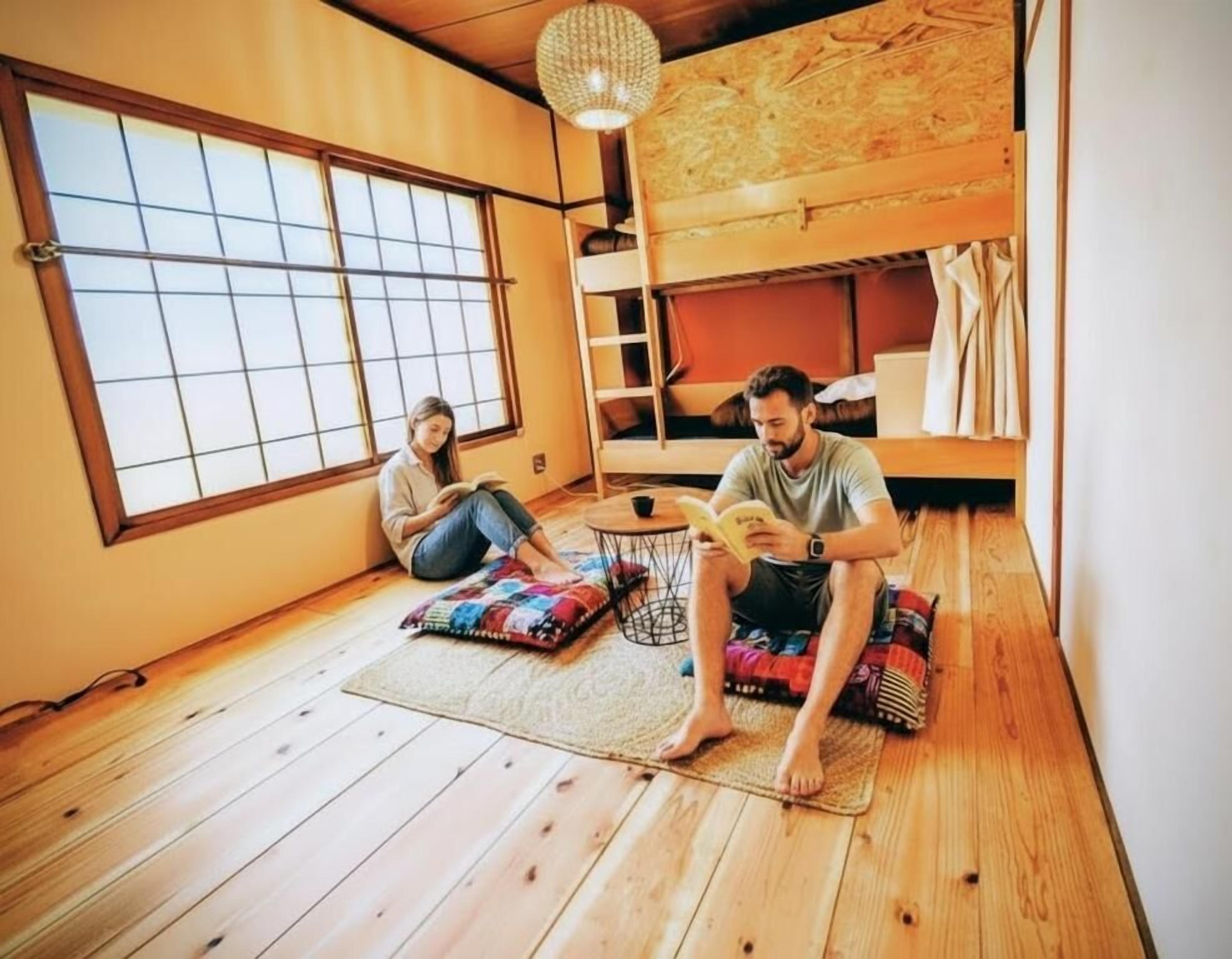 Ein Zimmer mit Etagenbett, großem Fenster und einer Leseecke mit Kissen.