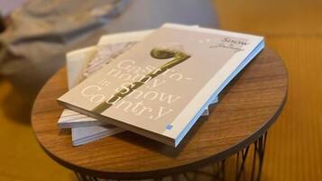 A small round table with a book titled 'Castaway Country' and a bag in the background.