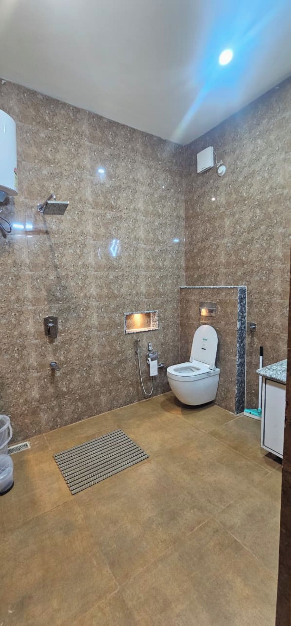 A bathroom with a toilet, shower, and sink.