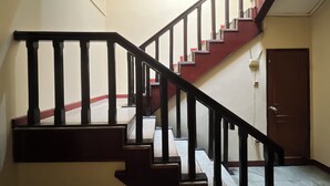 A staircase with black railings and red steps leading to a door. - Hotel Bandung Indah (Bandung)