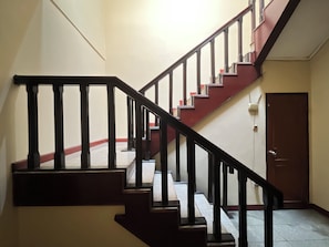 A staircase with black railings and red steps leading to a door. - Hotel Bandung Indah (Bandung)