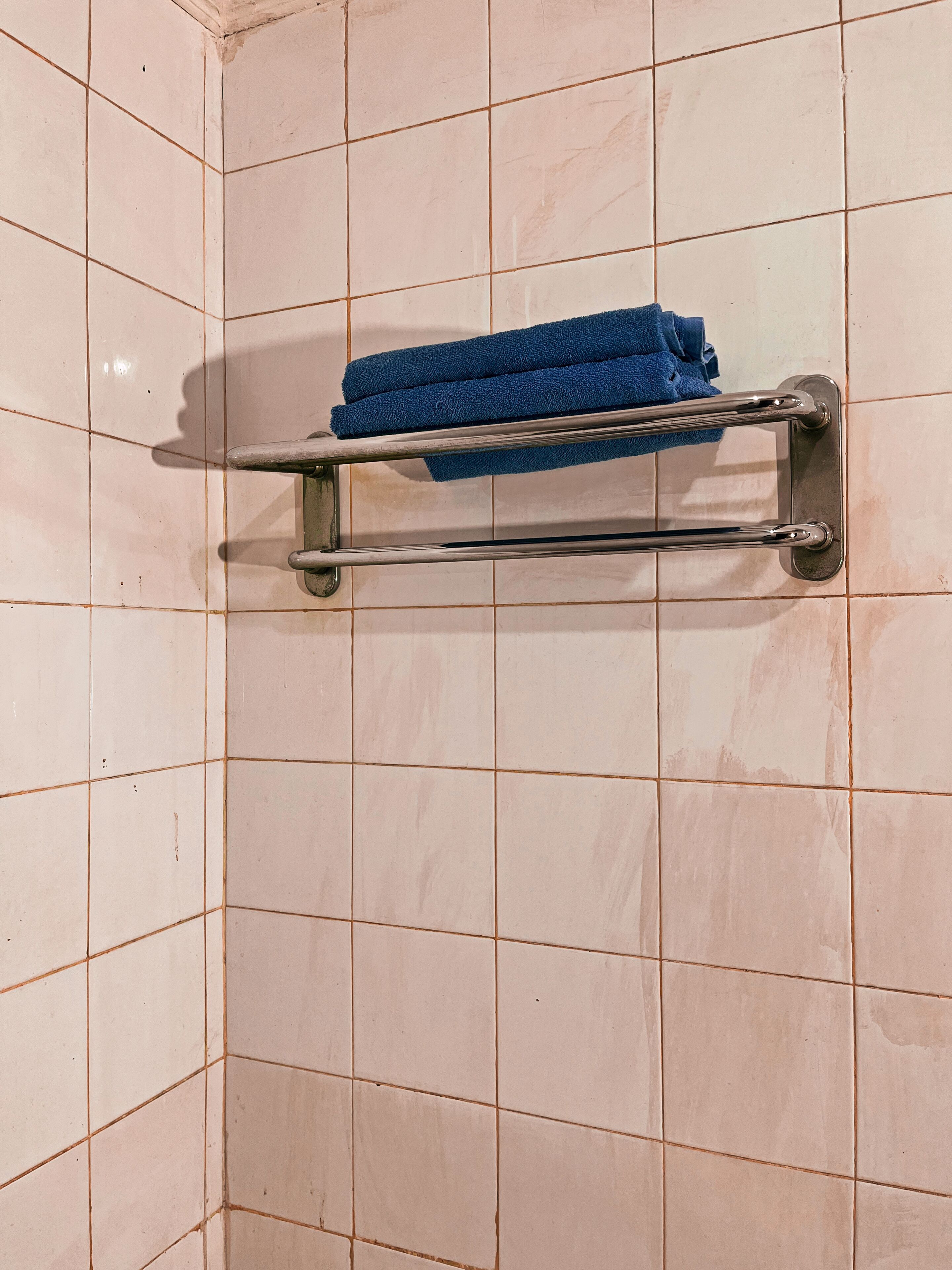 Un baño con un perchero que sostiene dos toallas.