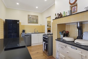 A kitchen with a black countertop, stainless steel appliances, and a tiled backsplash. - El Dorado | Sunny Family Home, Walk to Town (Katoomba)