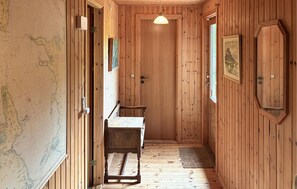 A wooden hallway with a bench, a door, and a hanging light fixture. - Stunning home in Kalundborg with sauna (Kalundborg)