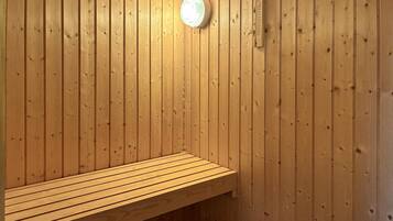 A wooden sauna bench with a light fixture on the wall.