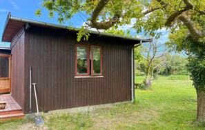 A wooden cabin with a window, a door, and a small porch area. - Stunning home in Kalundborg with sauna (Kalundborg)