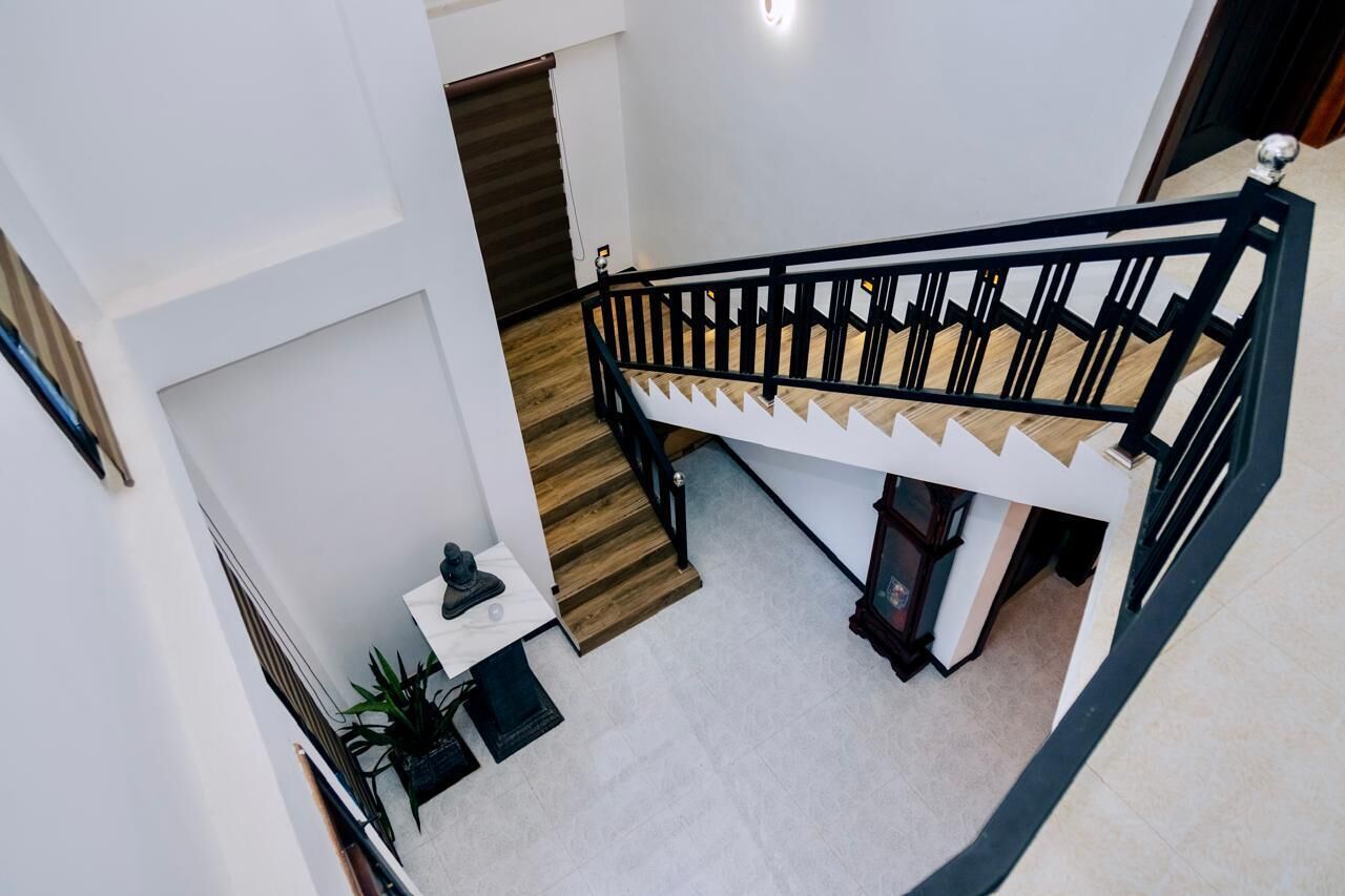 A modern interior with a staircase, a small table with a plant, and a white wall.