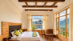 Un dormitorio con una cama de madera, vista a una casa azul y suelo de madera.