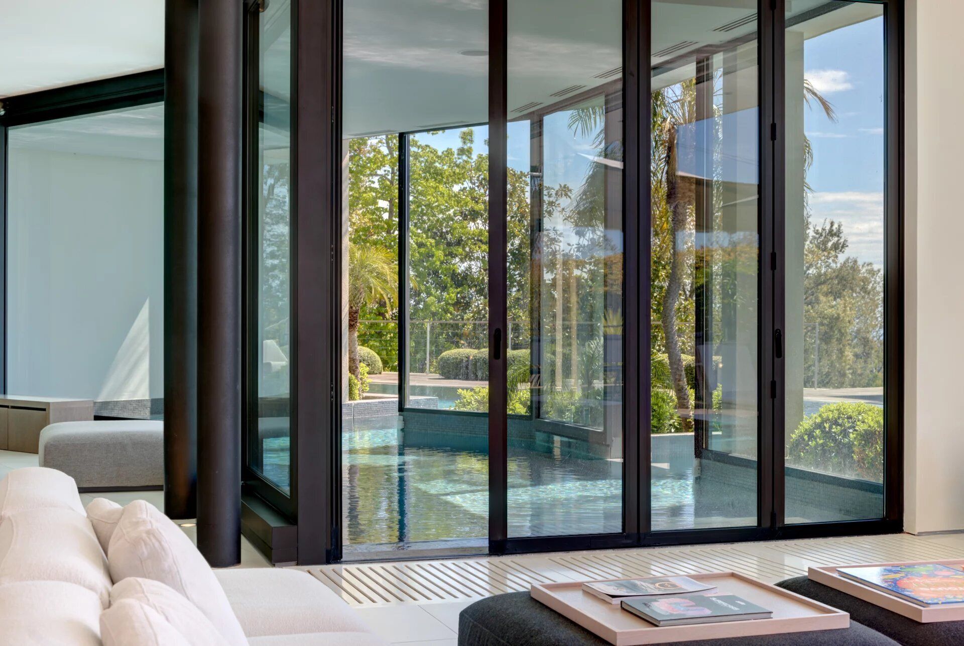 Quarto moderno com uma grande porta de correr de vidro que dá para uma área de piscina ao ar livre.