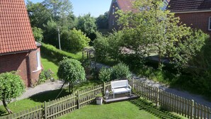 Un quartiere residenziale con case in mattoni, una recinzione in legno e una panchina nel giardino.