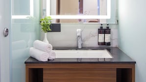 A bathroom with a mirror, sink, and wooden vanity. - Alaya Stays 1BHK Baljees Melville Utopia (Shimla)