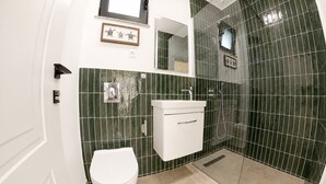 Une salle de bain moderne équipée de toilettes, d’un lavabo et d’une douche.