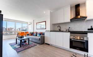 Eine moderne Wohnung mit Küche, Wohnbereich und großen Fenstern.