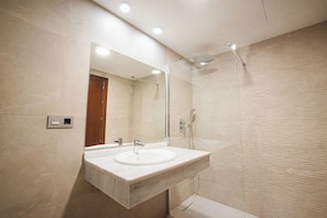 A modern bathroom with a sink, mirror, and shower. - HOTEL NOGAL (Peligros)