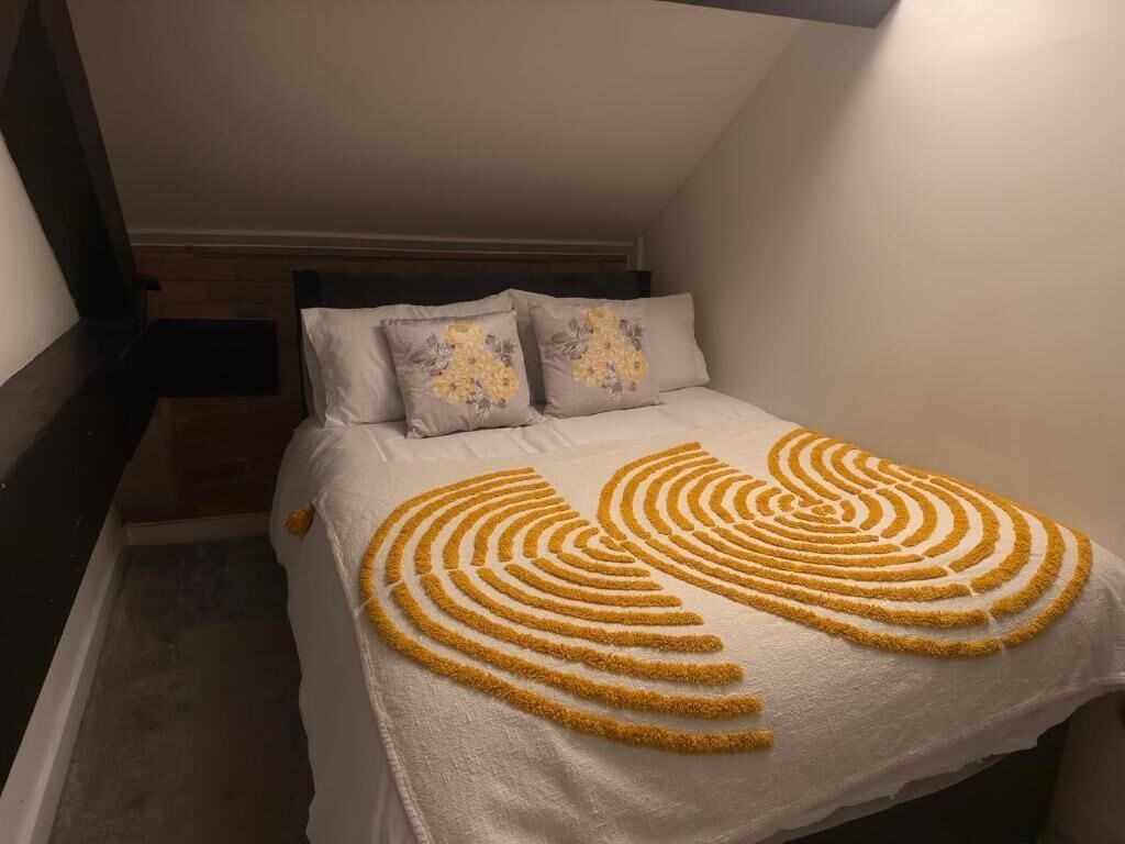 A bedroom with a bed, pillows, and a decorative towel.