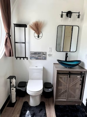 A compact bathroom with a toilet, bidet, and a vanity with a sink.