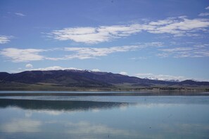 A calm lake with mountains in the background.