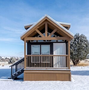 A wooden cabin with a balcony, a staircase, and a clear view of the surrounding landscape. - Private Rustic Chalet with Loft & Stunning Night Skies in Williams, Arizona (Williams)