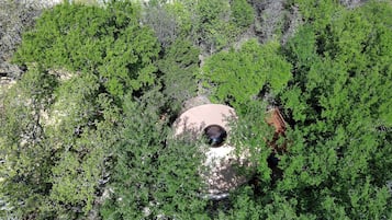 An aerial view of a building surrounded by dense green foliage.