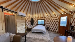A yurt interior with a bed, seating area, and a dining table. - Luxury Yurt makes for a Brilliant Texan Retreat (Mineral Wells)