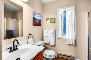 A bathroom with a sink, toilet, and a window with curtains. - Romantic Glamping Getaway in Love, Virginia's Natural Beauty (Love)