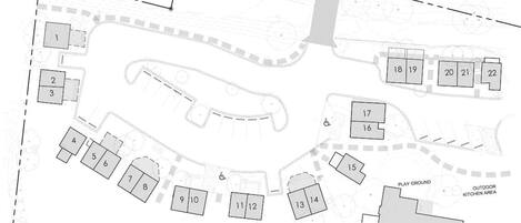 Plano de planta con habitaciones numeradas, un parque infantil y una casa de madera de dos pisos.