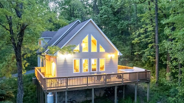 A house with a deck, surrounded by trees. - Family Time in Love, Virginia: Mountain Cabin Getaway (Love)