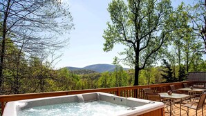 A hot tub on a wooden deck with outdoor furniture and a view of mountains. - Family Time in Love, Virginia: Mountain Cabin Getaway (Love)
